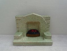 there is a small stone fireplace with strawberries on the fire place next to it
