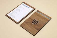 a wooden cutting board with a notepad and pen on it next to a piece of paper
