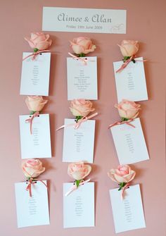 wedding seating cards with pink roses attached to them