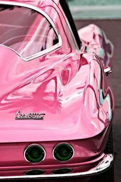 the front end of a pink car with chrome rims