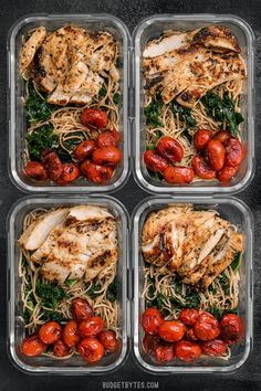four plastic containers filled with chicken, pasta and tomatoes on top of a black surface