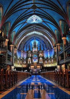 the inside of a large cathedral with stained glass windows and blue tile flooring in front of it