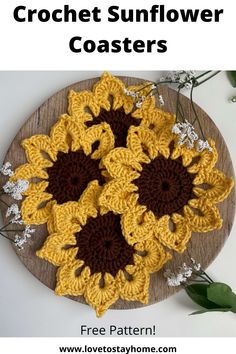 three crocheted sunflowers on a wooden plate