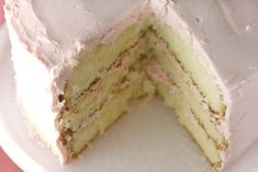 a white cake with pink frosting is cut into pieces