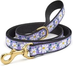 a dog leash with flowers on it and a gold metal hook attached to the leash