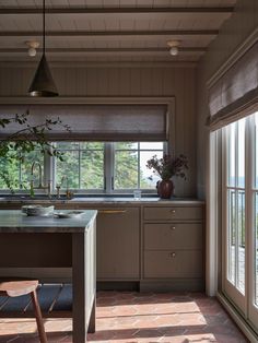 a kitchen with an island and windows overlooking the water