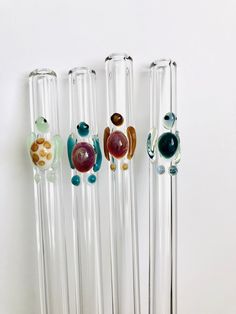 four glass tubes with different designs on them
