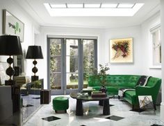 London designer Colin Radcliffe took his family's Notting Hill townhouse down to the studs, then fit it out with carefully calibrated luxe, creating a fresh take on bespoke glamour. The family room features a French mirrored cabinet and a pair of Maison Jansen lamps, all from the 1970s, a 1940s Italian sofa, and a 1960s artwork by Piero Fornasetti that has been turned into a light box; the throw is by Hermès.Tour the rest of the home. Architecture, Modern Sofa, Living Room Green