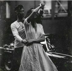 an old black and white photo of two people dancing