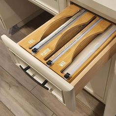 two wooden utensils are sitting in the drawers of a kitchen cabinet that is open