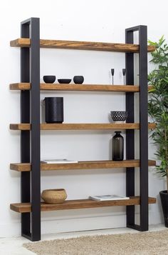 a wooden shelf with black metal legs and shelves on the wall next to a potted plant
