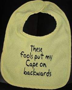 a bib with words written on it that says, these fools put my cape on backwardss