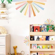 children's bookshelves and toys in a child's room with sunburst wall decal