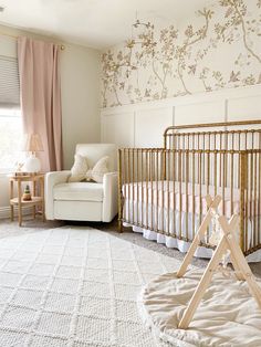 a baby's room with a crib, rocking chair and wallpaper on the walls
