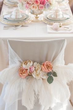 the table is decorated with flowers and feathers