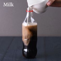 a person pours coffee into a glass bottle