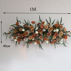 an arrangement of flowers is shown on the wall with measurements for each flower and foliage
