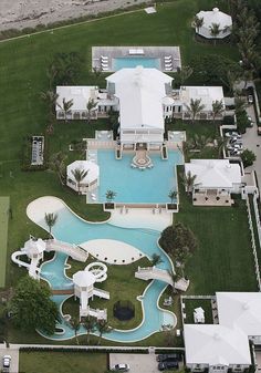 an aerial view of a large home with a pool in the middle and lots of lawn