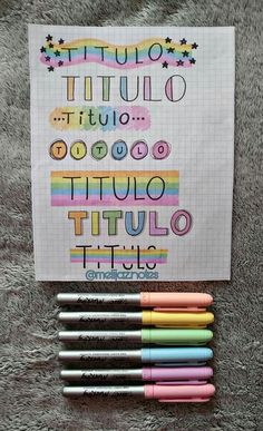 several pens are lined up in front of a piece of paper with the words titulo written on it