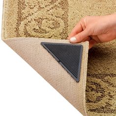 a person is placing a rug on the floor with a triangle shaped piece of carpet
