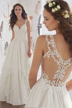 a woman in a wedding dress looking at the back of her gown with flowers on it