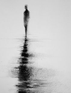 a black and white photo of a person standing in the water on a foggy day