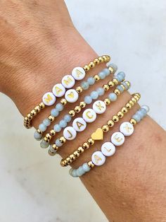 the personalized bracelets are decorated with white and gold beads, hearts, and letters