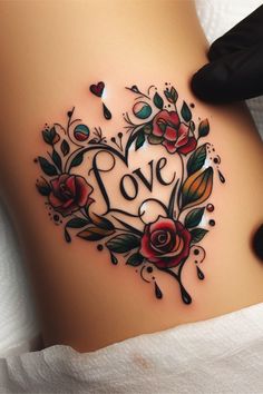 a woman's stomach with roses and the word love written on it in black ink