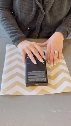 a woman using her cell phone on top of a chevron table cloth with an arrow pattern