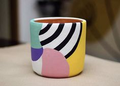 a colorful cup sitting on top of a table