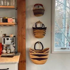 three baskets hanging on the wall above a counter