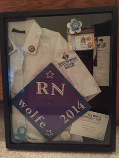 a framed shirt and other items are on display in a shadow box with the name rn wolf written on it