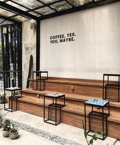 three tables sitting on the side of a building with coffee yes you maybe written on it
