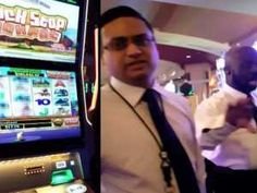 two men standing next to each other in front of slot machines