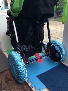 a stroller with blue and white polka dots on the wheels is sitting in front of a door