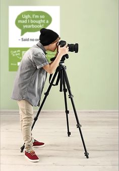 a person taking a photo with a camera on a tripod in an empty room