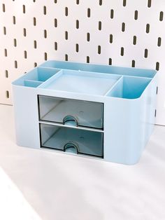 a blue drawer with four drawers on it and some holes in the wall behind it