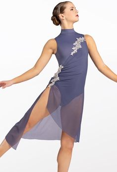 a woman in a purple dress is posing with her arms spread out to the side