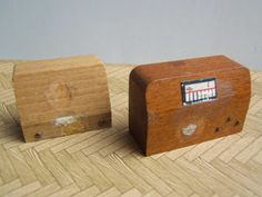 two small wooden boxes sitting on top of a wood floor next to each other,