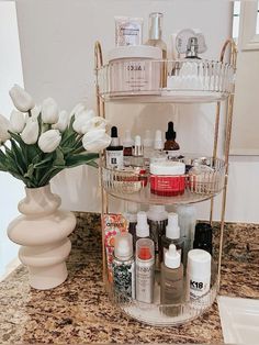 a bathroom counter with three tiered shelves holding cosmetics and other beauty products on it