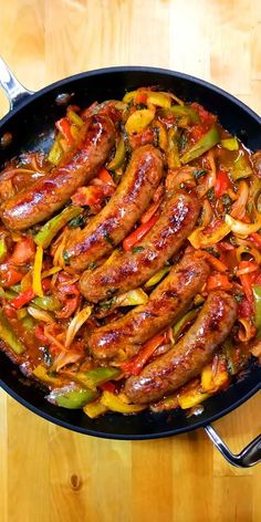 sausage and peppers in a skillet on a wooden table