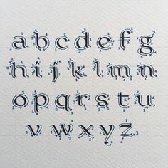 the upper and lower case of an english alphabet with drops of water on white paper