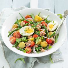 a white bowl filled with salad and eggs
