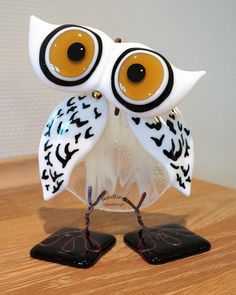 an owl figurine sitting on top of a wooden table