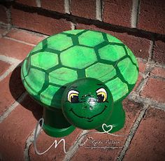 a green turtle phone sitting on top of a brick wall