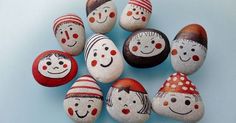 painted rocks are arranged in the shape of children's faces and hats on them