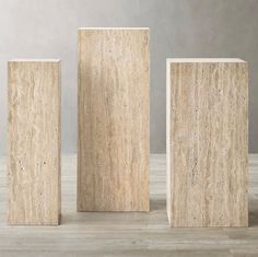 three stone blocks sitting on top of a wooden floor