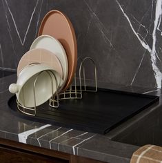 three plates are stacked on top of each other in front of a marble countertop