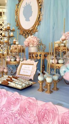 a table topped with lots of cakes and desserts covered in pink flowers next to a mirror