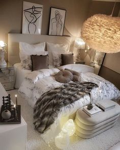 a large bed sitting in the middle of a bedroom next to two lamps and pictures on the wall